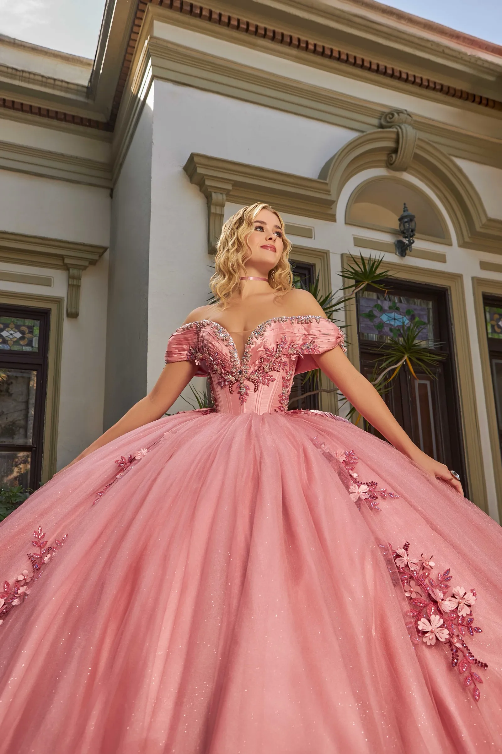 Quinceañera in a pink gown in a grand hall