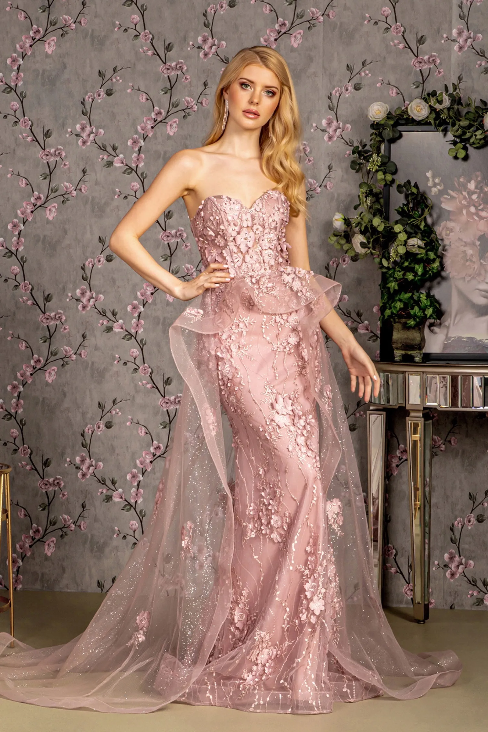 Pink floral prom gown against a painted wall